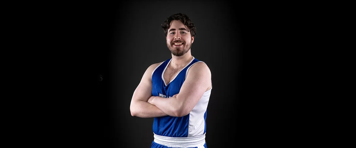 Hugo Wickham stands wearing boxing clothing on a background