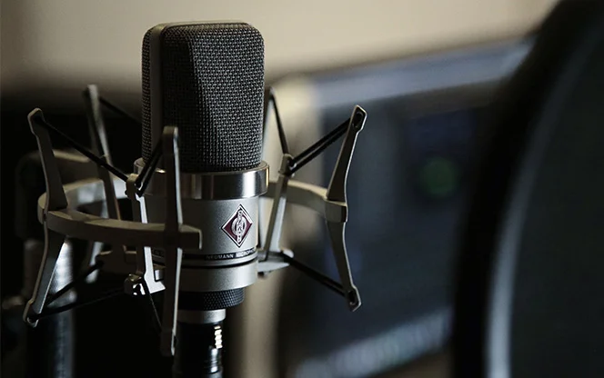 A condenser microphone with a pop filter ready to be used for the ACT-BT podcast