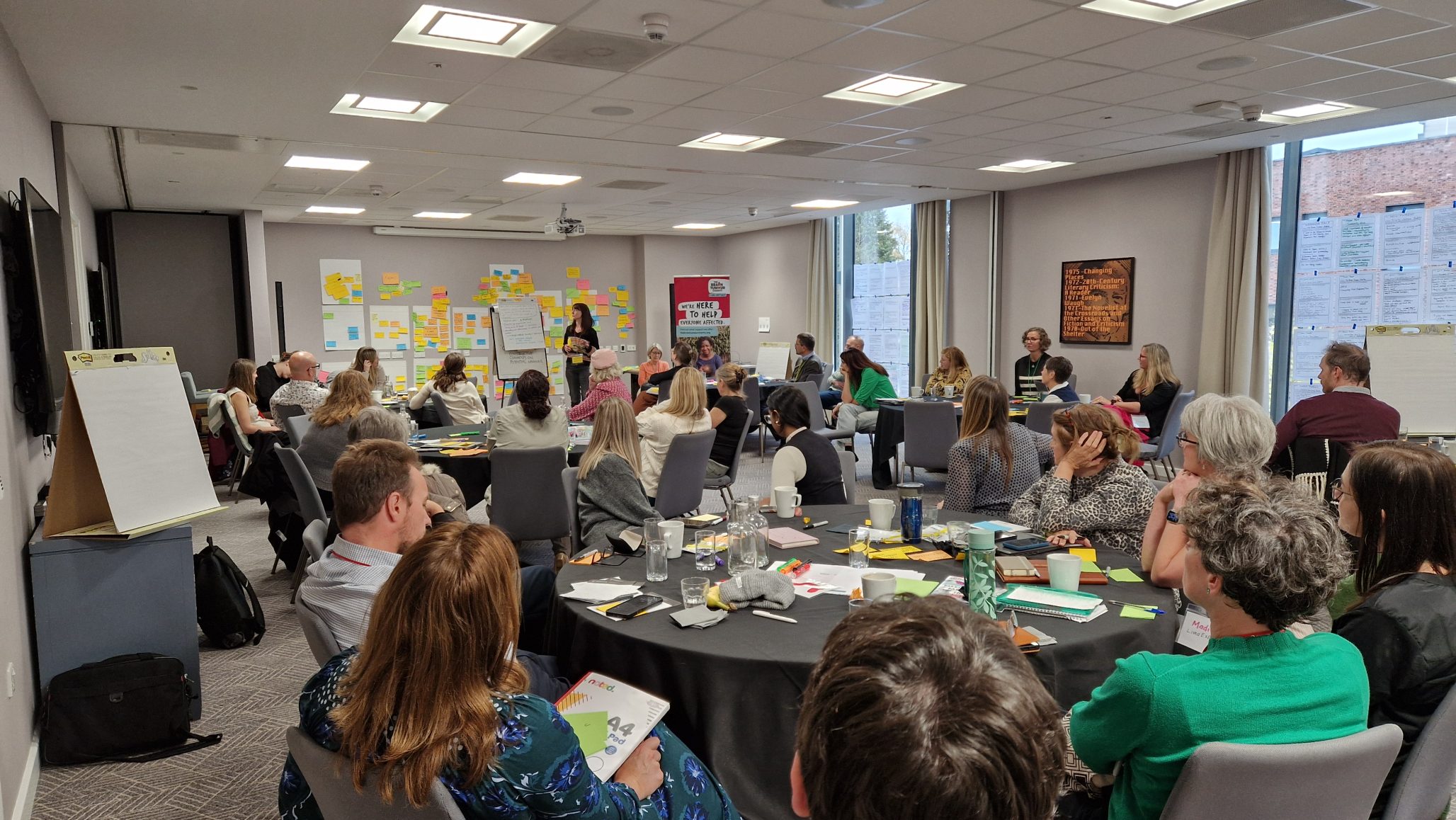 People sit around round tables at a sandpit designed to identify some of the biggest gaps in support and develop research ideas for living better with a brain tumour.