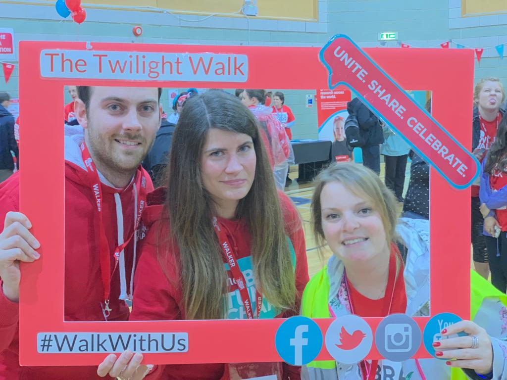 April and Emma hold up a frame at The Twilight Walk and smile from inside it, celebrating their bond and friendship
