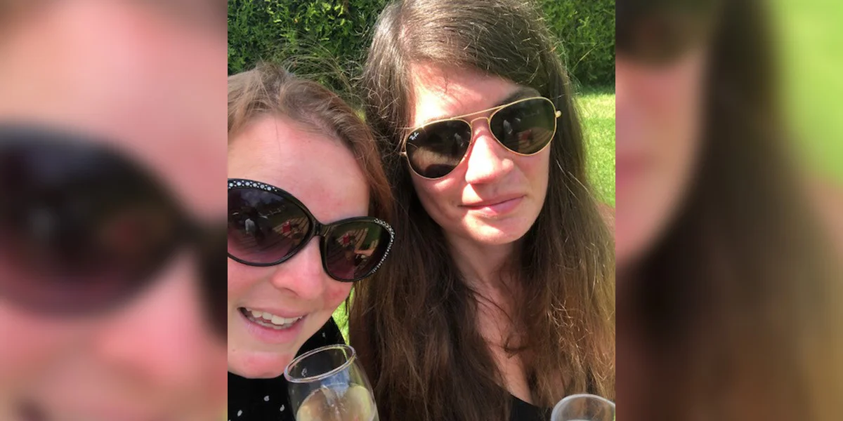 April and Emma are Young Ambassadors who became friends. They sit on grass holding glasses of fizz.
